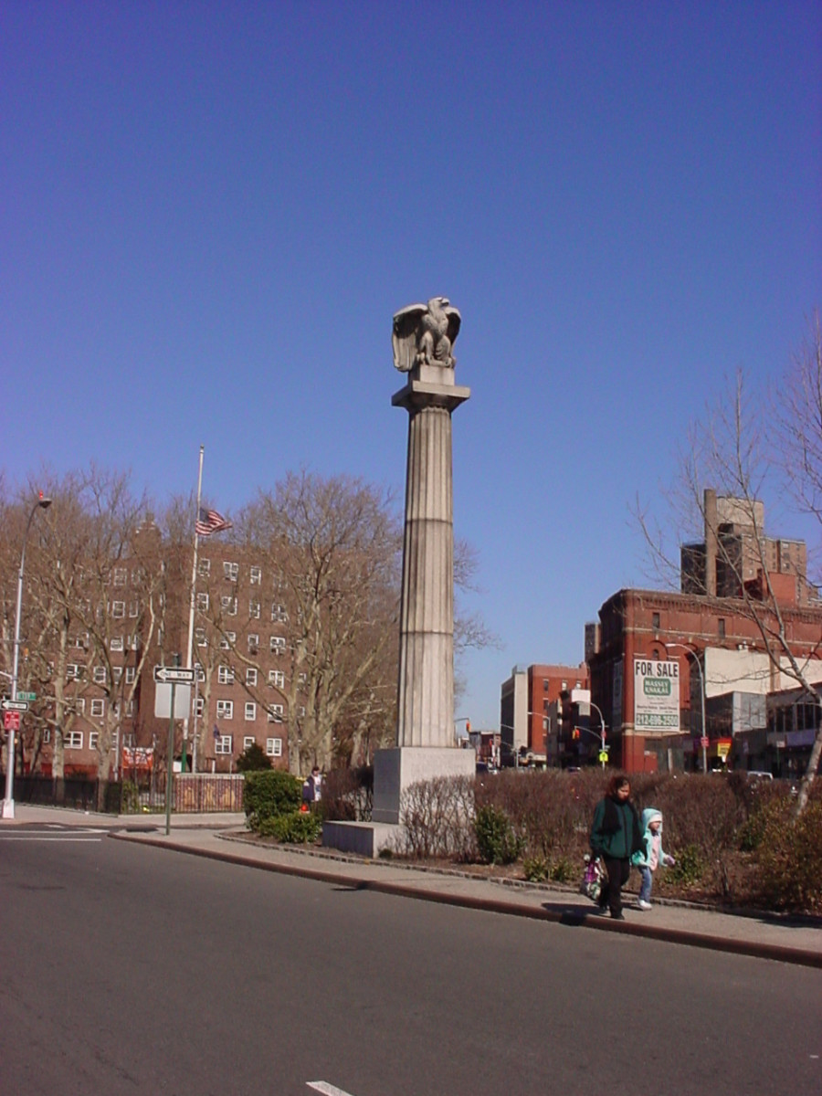 Fluted rostral column topped with an eagle and inscribed with honor roll, on pedestal with bronze plaque