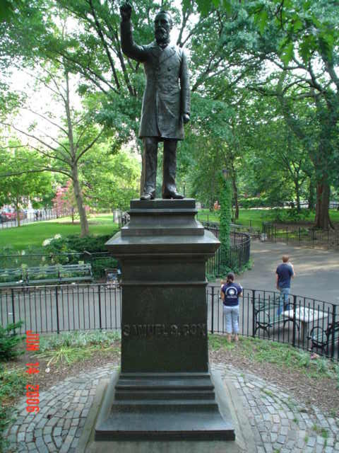 Standing figure (over life-size) with integral plinth, on pedestal with two plaques, on base