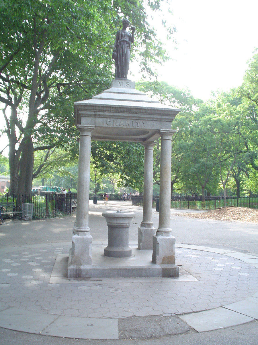 Square kiosk with four supporting columns over a drinking fountain, finial female figure on pedestal