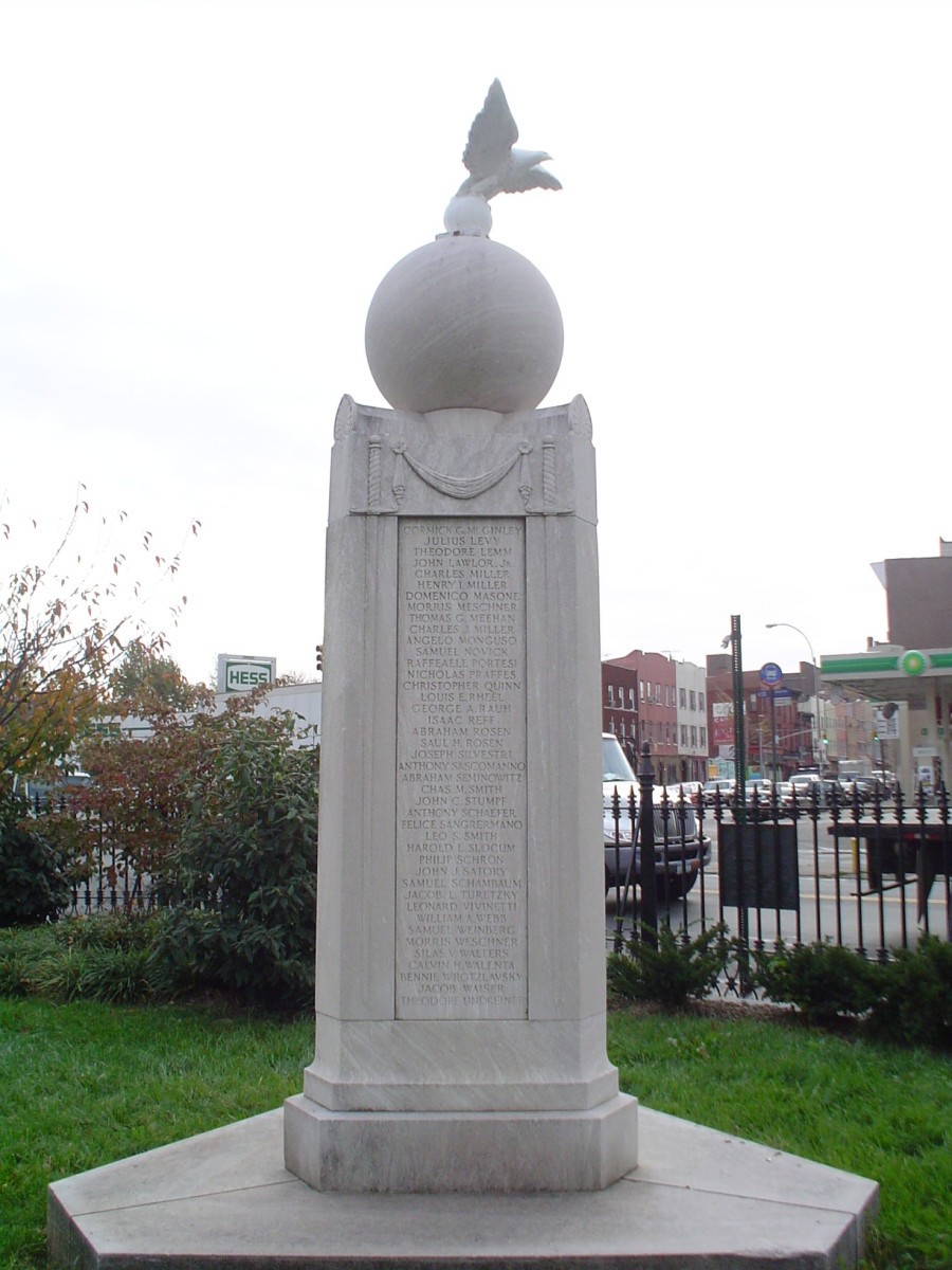 Eagle on ball on triangular shaft on plinth; small tablet on ground with dedication date