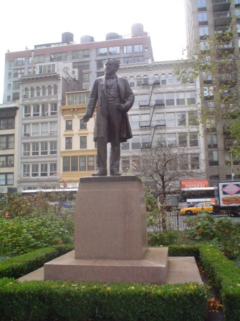 Standing figure (over life size) with integral plinth, on pedestal