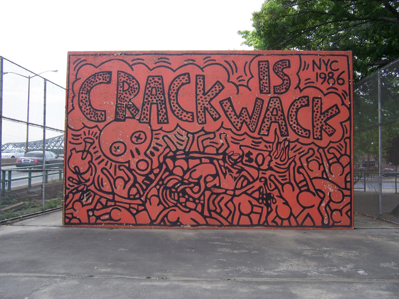 Two murals on either side of concrete handball wall