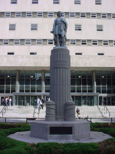 Standing figure on base, on plinth