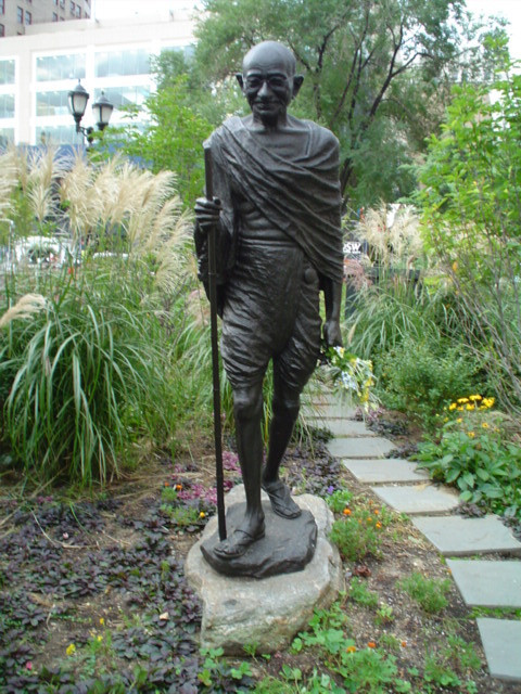 Standing figure (over life-size) with integral plinth on pedestal with plaque