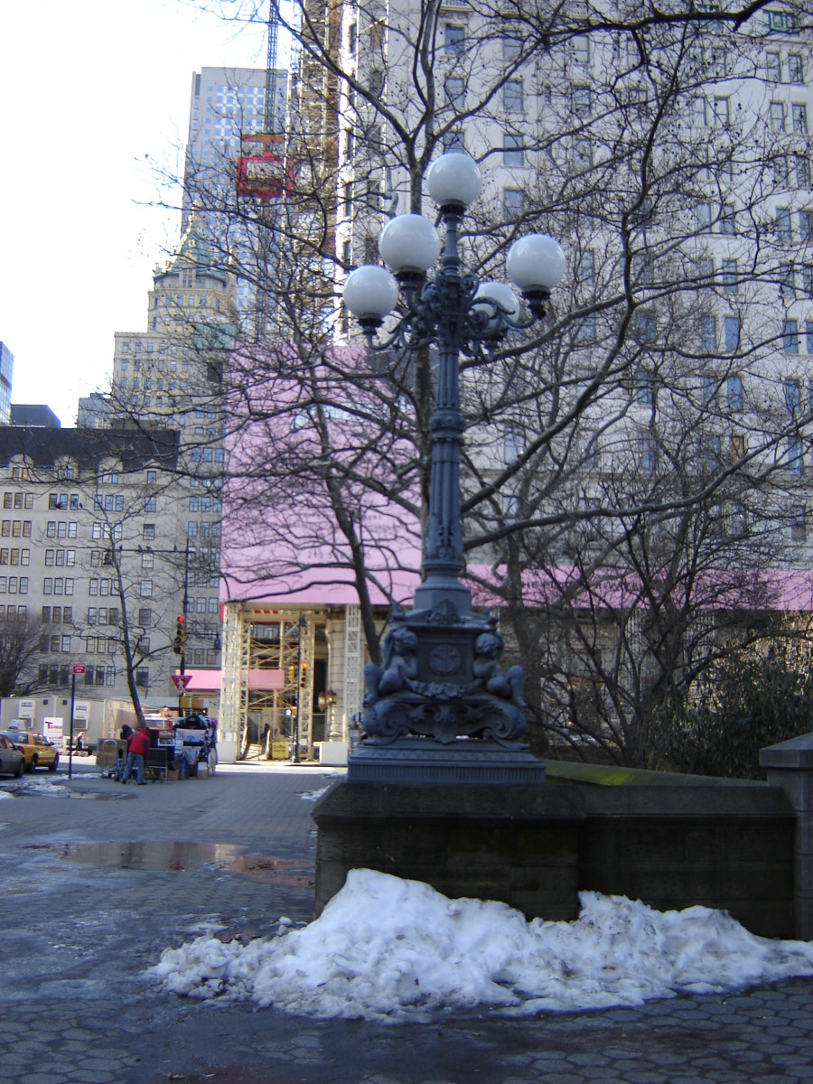 Street lamp adorned with a pair of infant figures at each of four corners of base, plaque