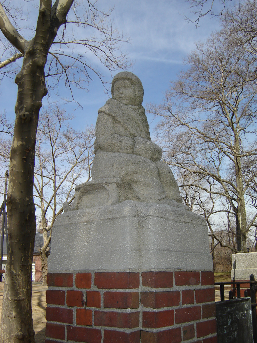 Two figures, each at the top of a gatepost