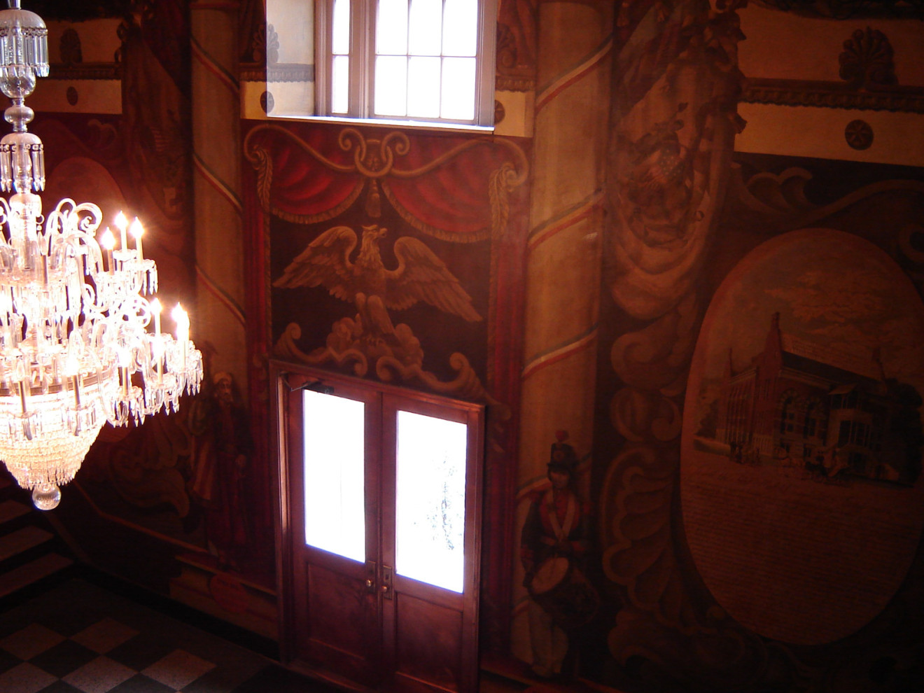 Mural covering north, east, and south walls of lobby, and continuing on west wall at balcony level; complementary painted decoration of west wall and two columns at lobby level