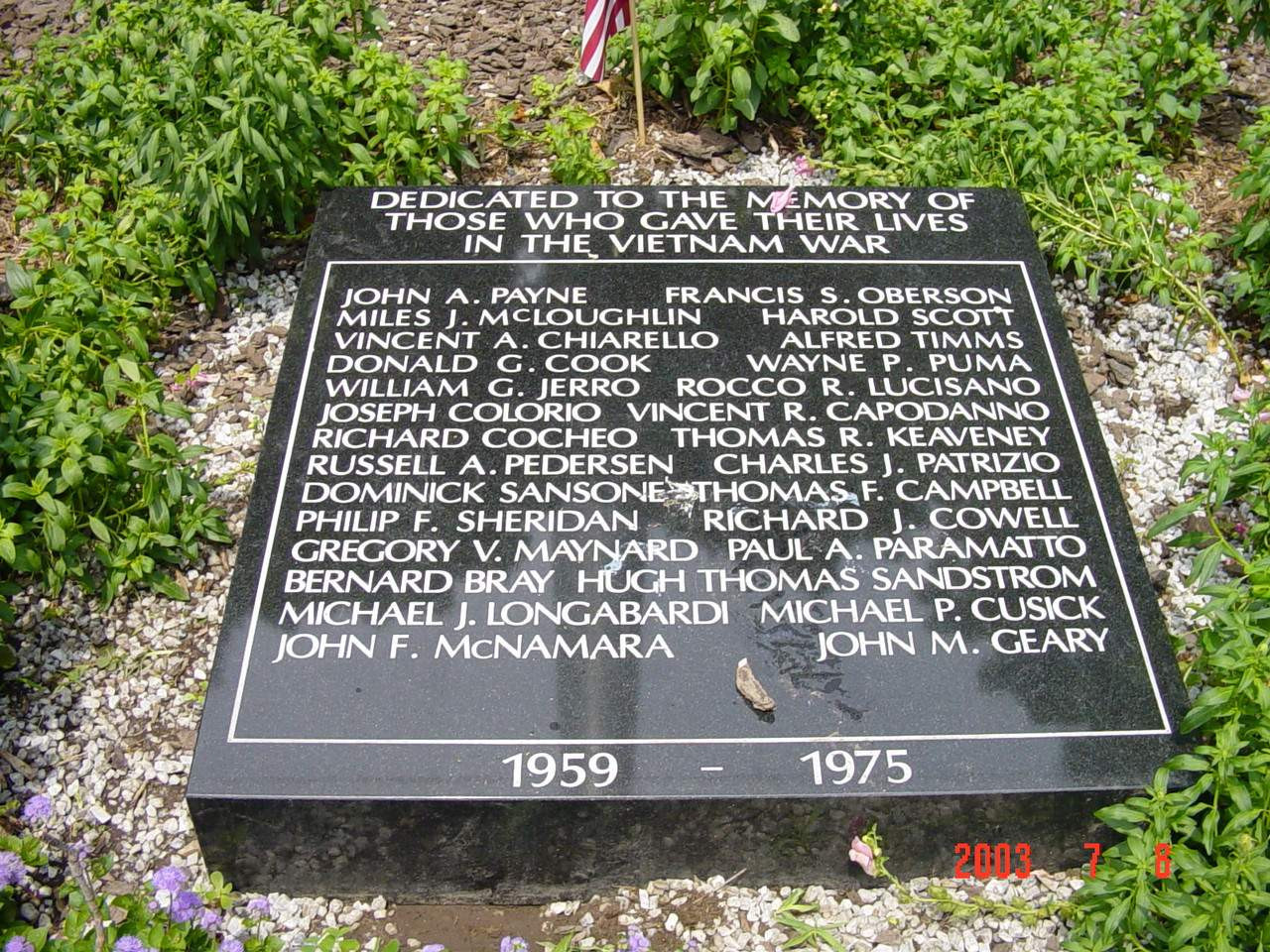 Stone marker in planting bed