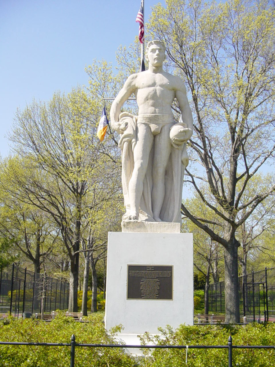 Standing male figure with plaque mounted on front of pedestal