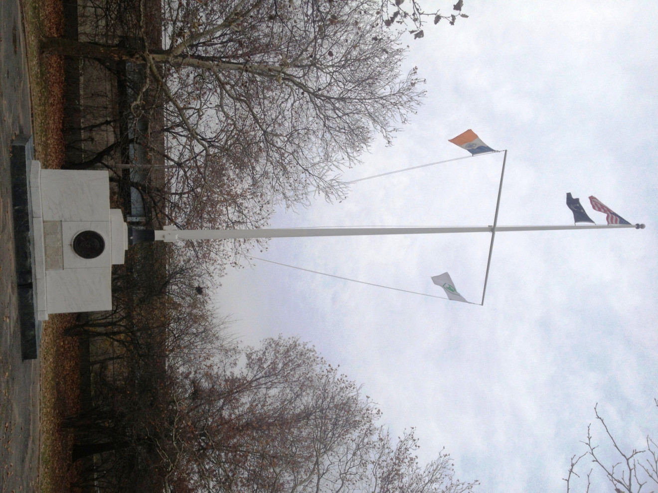 Flagpole base, ornamental pedestal with circular relief sculpture