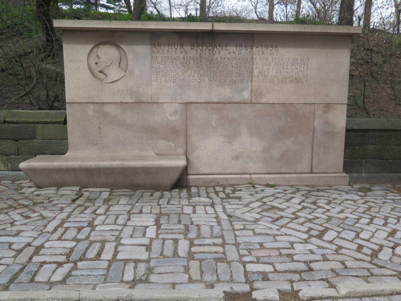 Shaft with bench beside it (all one piece) with sunken bas-relief medallion above the bench