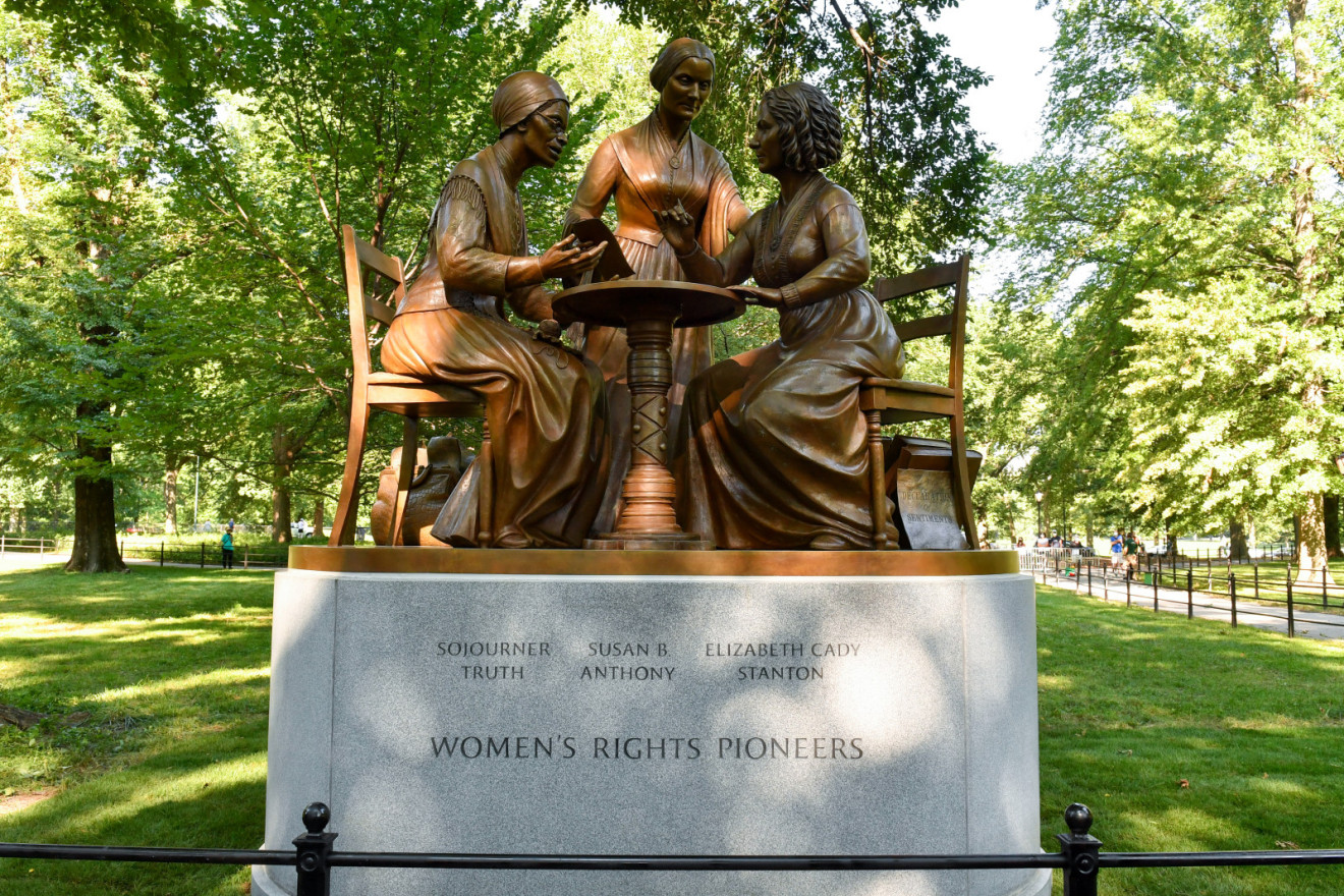 Group of one standing and two seated figures (over life size) on integral plinth and pedestal