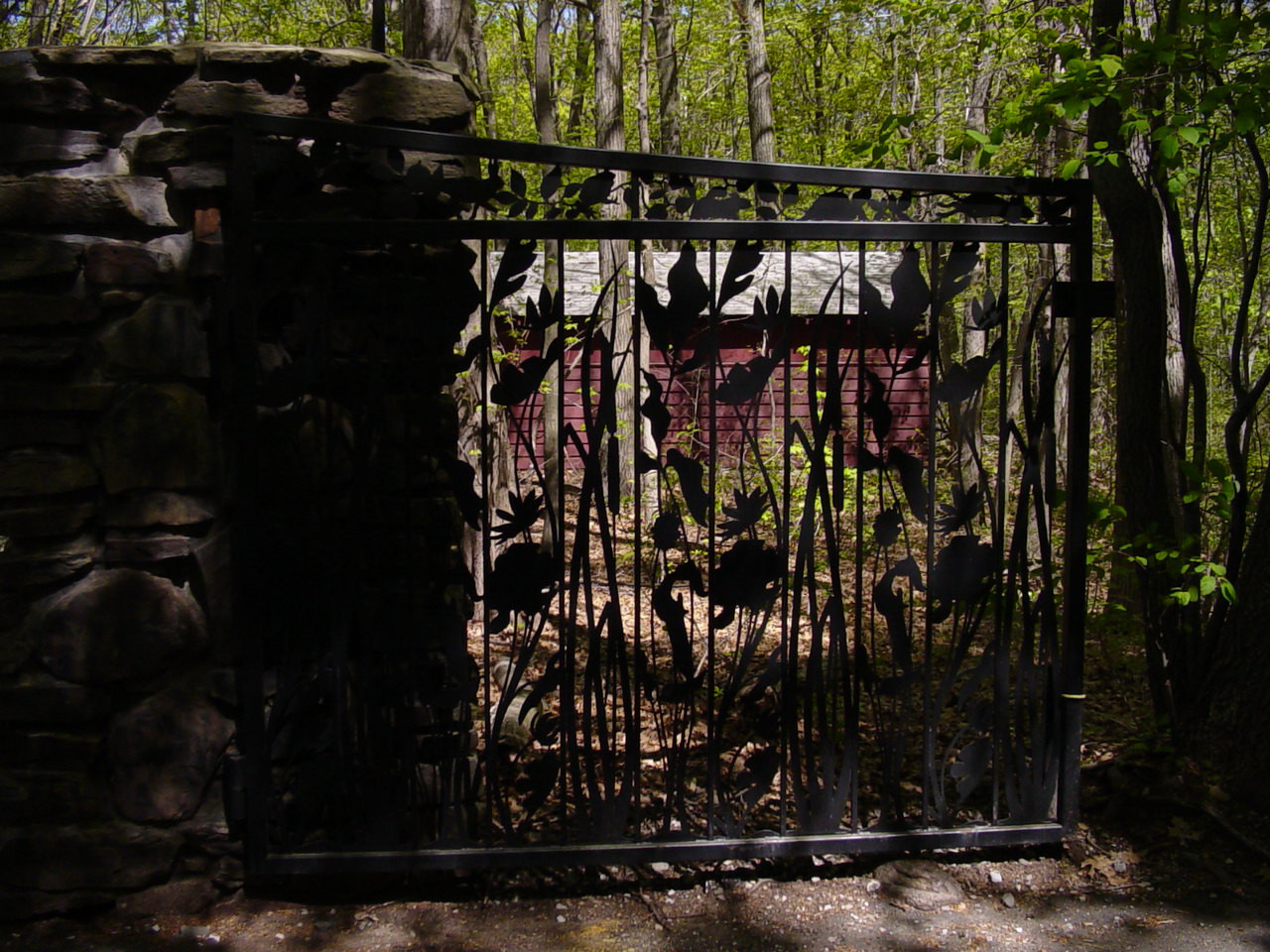 Gate of two leaves with openwork pattern, hung on two piers, with plaque mounted on one of the piers