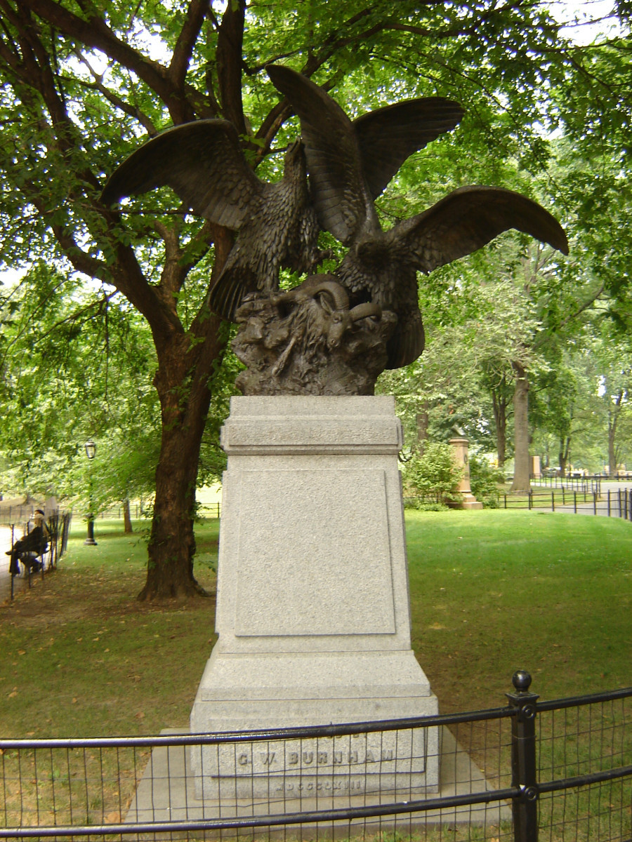 Group of two birds attacking a goat, on a pedestal