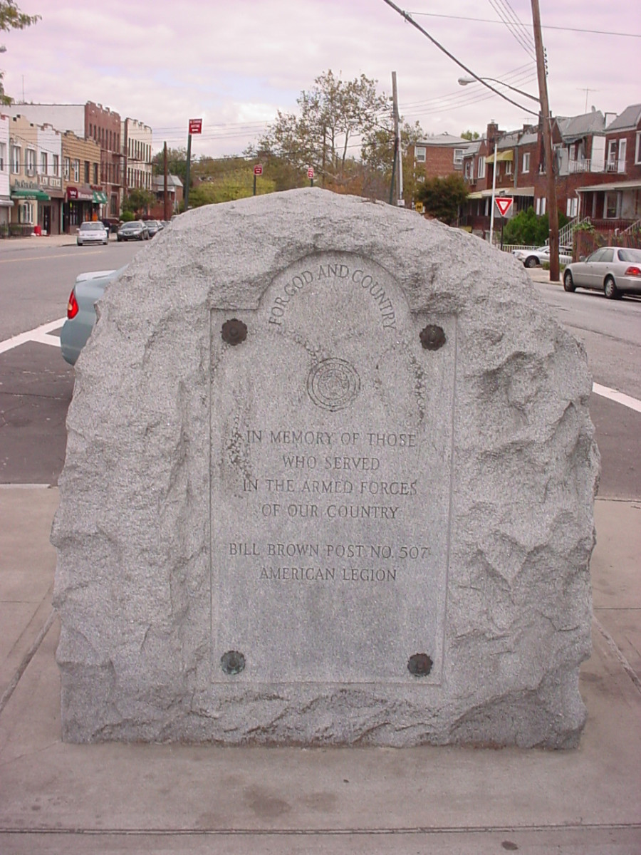 Large boulder with rough-hewn finish; incised inscription with bronze rosettes