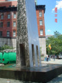 Tall obelisk with variegated surface on a pentagonal base; plaque