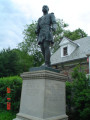 Standing figure on integral plinth, on pedestal