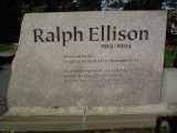 Sculpture; rectangular bronze structure with cut-out male figure; four engraved stone markers