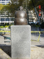 Seated figure on pedestal on base