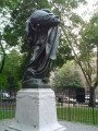 Standing male figure (heroic scale) with integral plinth on pedestal raised on three steps, tablet