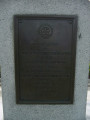 Standing figure (life size), on pedestal with four plaques