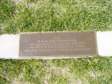 Standing male figure with plaque mounted on front of pedestal