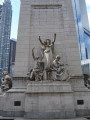 Pylon fountain embellished with colossal group, nine figures (heroic scale), and frieze; three plaques (two large, one small); four gate houses, each with a door and three low reliefs