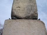 Obelisk supported by bronze crabs at four corners of base, on a block on a square terrace, plaques