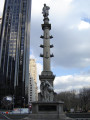 Standing figue (colossal scale) on rostral column on pedestal, base, and plinth; pedestal figure of a winged youth examining a globe; two bas-reliefs on base