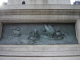 Standing figue (colossal scale) on rostral column on pedestal, base, and plinth; pedestal figure of a winged youth examining a globe; two bas-reliefs on base