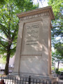 Seated figure (over life-size), on pedestal, under a canopy