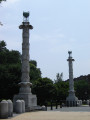 Two columns on high square plinths, each topped by a tripod and bowl