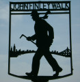 Two cutout silhouettes of walking figure and name attached to pole