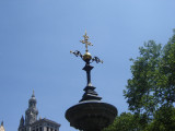 Square pool with candelabrum at each corner; central column consisting of circular basin with umbrella above, surmounted by fixture