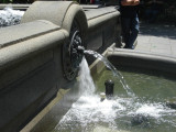 Square pool with candelabrum at each corner; central column consisting of circular basin with umbrella above, surmounted by fixture