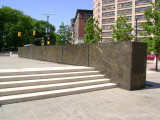 Heroic scale bronze figure, bronze fountain wall, and decorative paving and seating blocks