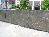 Heroic scale bronze figure, bronze fountain wall, and decorative paving and seating blocks