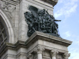 Triumphal arch; bas-relief figures in spandrels on south face; seal of city of Brooklyn and seal of New York state in spanrels on north face; sixteen medallions, four on each of the pier stages at south and north faces