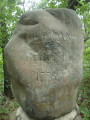 Large boulder resting on several medium-sized boulders, supported by about a dozen small boulders