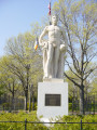 Standing male figure with plaque mounted on front of pedestal