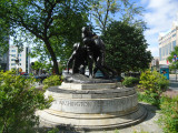 Group of three doughboy figures (over life-size) with integral plinth on a low base that rests on a circular pedestal; twenty plaques facing upward and carrying the names of the dead surround  the group