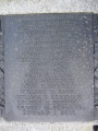 Group of three doughboy figures (over life-size) with integral plinth on a low base that rests on a circular pedestal; twenty plaques facing upward and carrying the names of the dead surround  the group