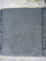 Group of three doughboy figures (over life-size) with integral plinth on a low base that rests on a circular pedestal; twenty plaques facing upward and carrying the names of the dead surround  the group