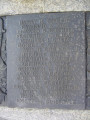 Group of three doughboy figures (over life-size) with integral plinth on a low base that rests on a circular pedestal; twenty plaques facing upward and carrying the names of the dead surround  the group