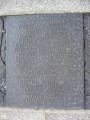 Group of three doughboy figures (over life-size) with integral plinth on a low base that rests on a circular pedestal; twenty plaques facing upward and carrying the names of the dead surround  the group