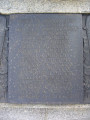 Group of three doughboy figures (over life-size) with integral plinth on a low base that rests on a circular pedestal; twenty plaques facing upward and carrying the names of the dead surround  the group