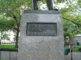 Figure (heroic scale) on integral plinth, pedestal with four recessed relief plaques