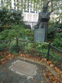 Standing three-quarter figure on base, plaque on ground