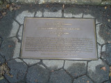 Standing three-quarter figure on base, plaque on ground