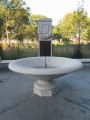 Inscribed cenotaph with three large plaques (one broad, two narrow), one medium plaque, and seven small plaques; fountain; two benches